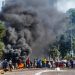 Looters outside a shopping centre alongside a burning barricade in Durban, South Africa, Monday July 12, 2021. Police say six people are dead and more than 200 have been arrested amid escalating violence during rioting that broke out following the imprisonment of South Africa's former President Jacob Zuma. (AP Photo/Andre Swart)